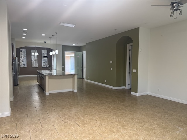 7934 Cape Flattery Ave, Las Vegas, NV 89147 - unfurnished living room with arched walkways, a sink, baseboards, ceiling fan, and recessed lighting