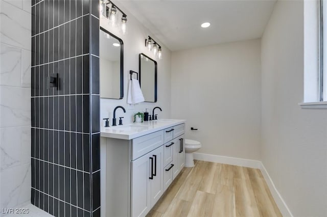 6100 Fawn Cir, Las Vegas, NV 89107 - bathroom with double vanity, toilet, wood finished floors, tiled shower, and baseboards
