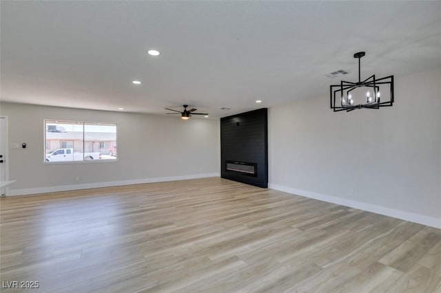 6100 Fawn Cir, Las Vegas, NV 89107 - unfurnished living room with a large fireplace, light wood-type flooring, a ceiling fan, recessed lighting, and a chandelier
