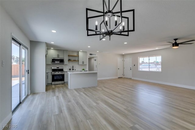 6100 Fawn Cir, Las Vegas, NV 89107 - unfurnished living room with recessed lighting, baseboards, light wood-style flooring, a sink, and a chandelier