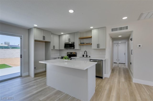 6100 Fawn Cir, Las Vegas, NV 89107 - kitchen featuring stainless steel appliances, open shelves, a sink, baseboards, and light countertops