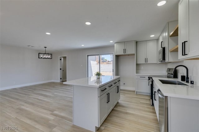 6100 Fawn Cir, Las Vegas, NV 89107 - kitchen featuring a sink, appliances with stainless steel finishes, light wood-type flooring, open shelves, and light countertops