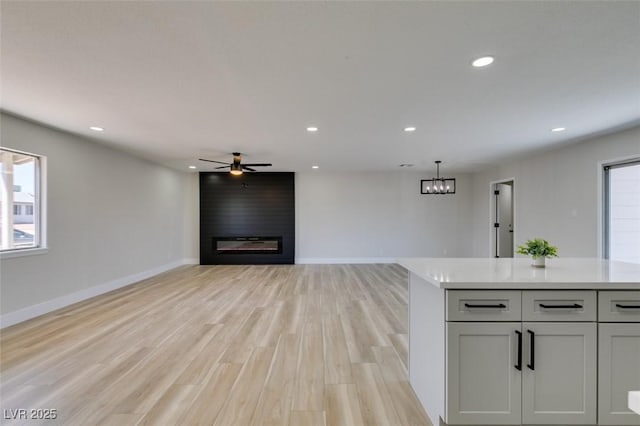 6100 Fawn Cir, Las Vegas, NV 89107 - unfurnished living room featuring a large fireplace, recessed lighting, light wood-type flooring, baseboards, and ceiling fan