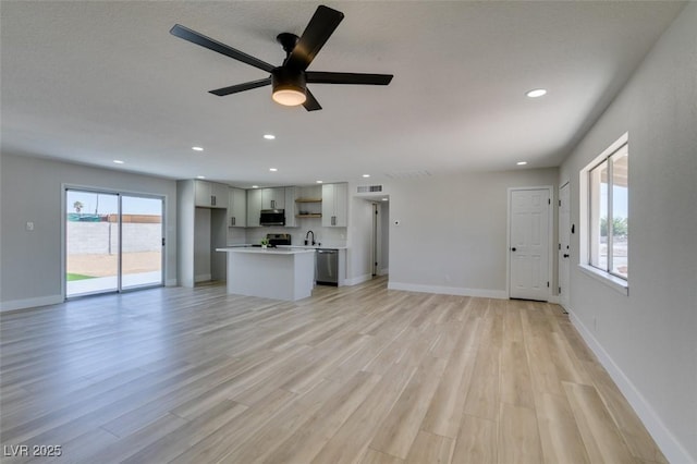 6100 Fawn Cir, Las Vegas, NV 89107 - unfurnished living room with light wood-style floors, ceiling fan, baseboards, recessed lighting, and a sink
