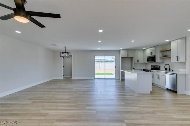 6100 Fawn Cir, Las Vegas, NV 89107 - kitchen with stainless steel appliances, open shelves, light wood-style flooring, recessed lighting, and light countertops