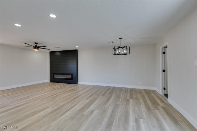 6100 Fawn Cir, Las Vegas, NV 89107 - unfurnished living room with ceiling fan, a chandelier, baseboards, recessed lighting, and light wood-style flooring