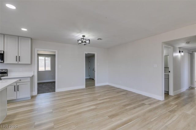 4360 El Tovar Rd, Las Vegas, NV 89115 - unfurnished living room featuring baseboards, recessed lighting, light wood-style floors, and a chandelier
