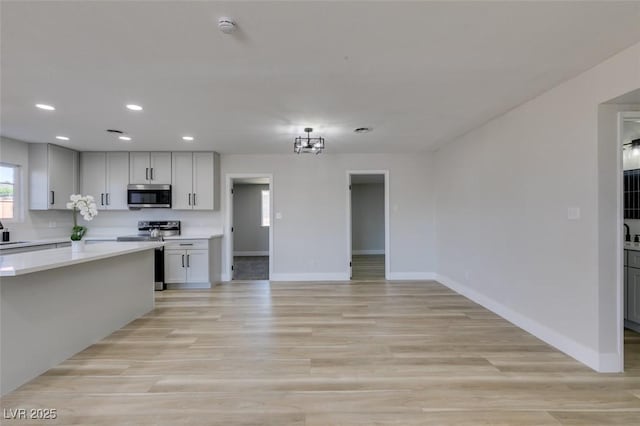 4360 El Tovar Rd, Las Vegas, NV 89115 - kitchen featuring stainless steel appliances, baseboards, light countertops, recessed lighting, and light wood-style flooring