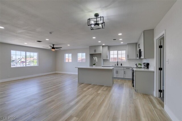 4360 El Tovar Rd, Las Vegas, NV 89115 - kitchen with a sink, stainless steel appliances, a kitchen island, recessed lighting, and baseboards
