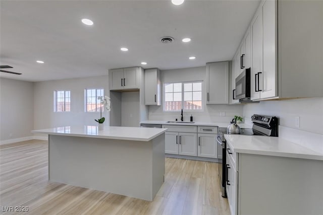 4360 El Tovar Rd, Las Vegas, NV 89115 - kitchen with stainless steel electric stove, a sink, healthy amount of natural light, light wood finished floors, and recessed lighting