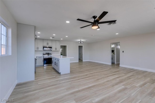 4360 El Tovar Rd, Las Vegas, NV 89115 - kitchen featuring appliances with stainless steel finishes, light countertops, open floor plan, a ceiling fan, and baseboards