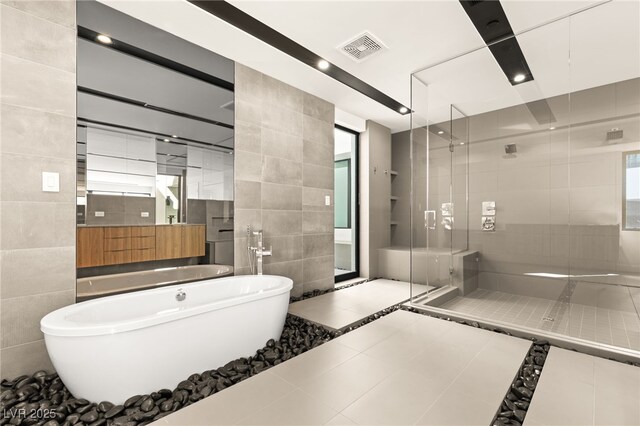 25 Canyon Bay Dr, Henderson, NV 89011 - bathroom featuring tile walls, a soaking tub, a stall shower, tile patterned flooring, and vanity