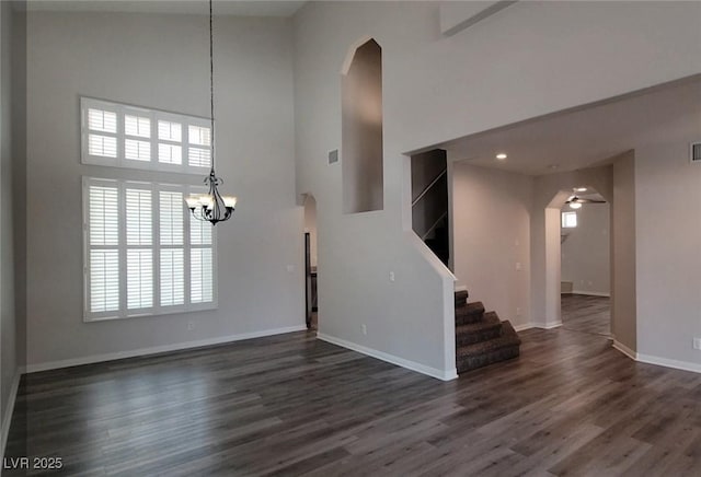 5509 Big Sky Ln, Las Vegas, NV 89149 - entrance foyer with arched walkways, a high ceiling, a chandelier, dark wood-style flooring, and baseboards