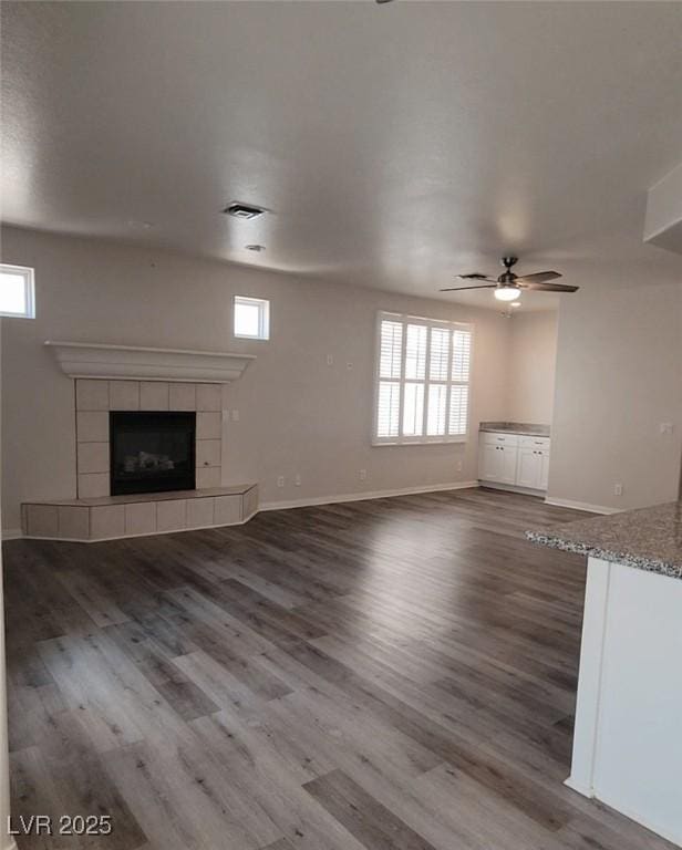 5509 Big Sky Ln, Las Vegas, NV 89149 - unfurnished living room featuring ceiling fan, wood finished floors, plenty of natural light, and a fireplace