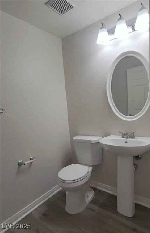 5509 Big Sky Ln, Las Vegas, NV 89149 - half bath with wood finished floors, toilet, baseboards, and a sink