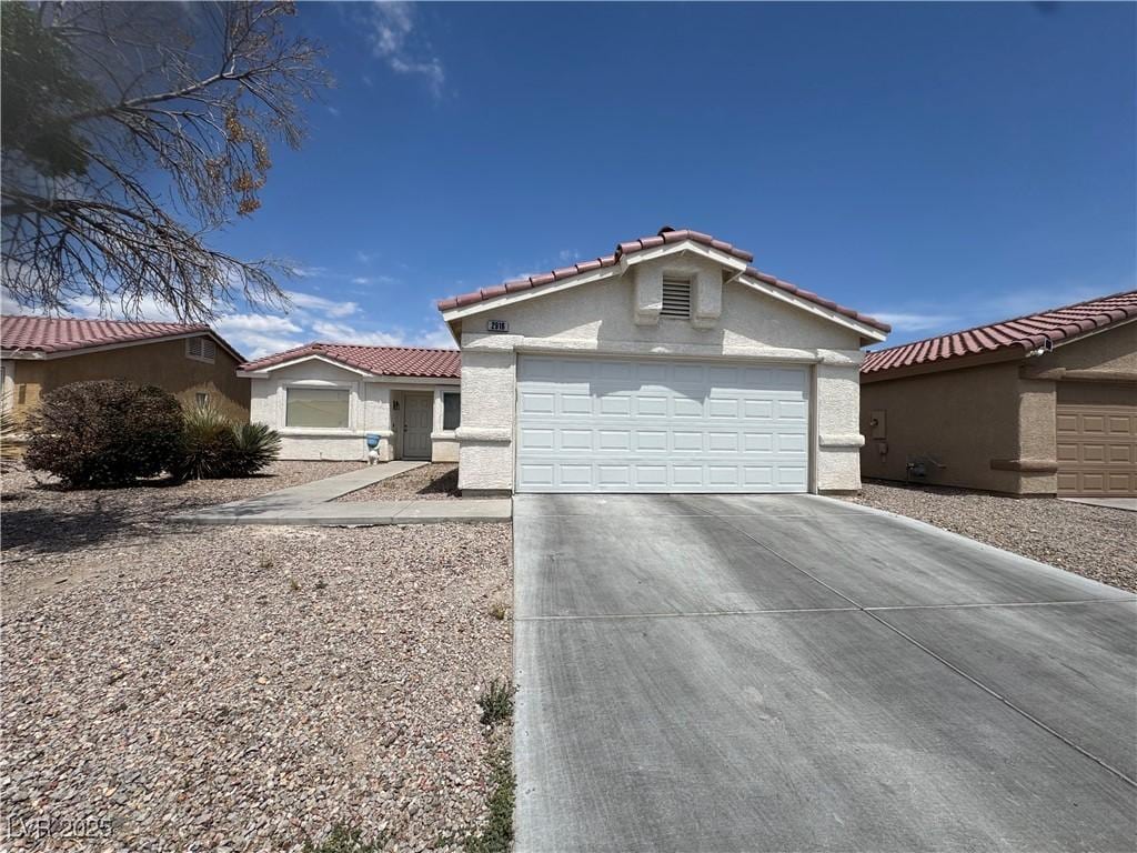 2916 Honeysuckle Ave, North Las Vegas, NV 89031 - view of front of property featuring an attached garage, concrete driveway, stucco siding, and a tiled roof