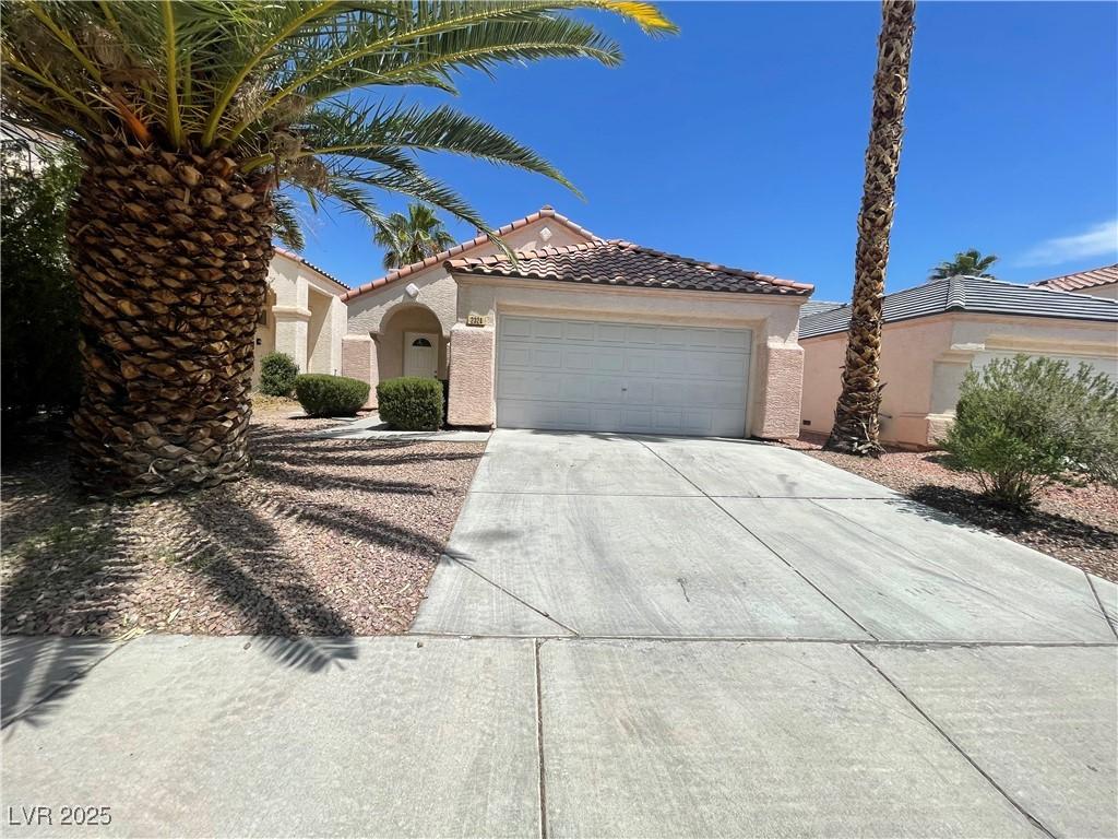 2324 Catskill Ct, North Las Vegas, NV 89031 - mediterranean / spanish-style home featuring stucco siding, driveway, a garage, and a tile roof