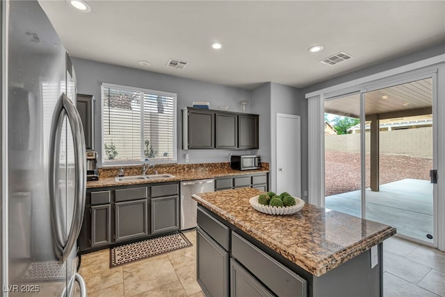 10952 Napa Ridge Dr, Las Vegas, NV 89144 - kitchen with appliances with stainless steel finishes, recessed lighting, gray cabinetry, dark stone counters, and a kitchen island