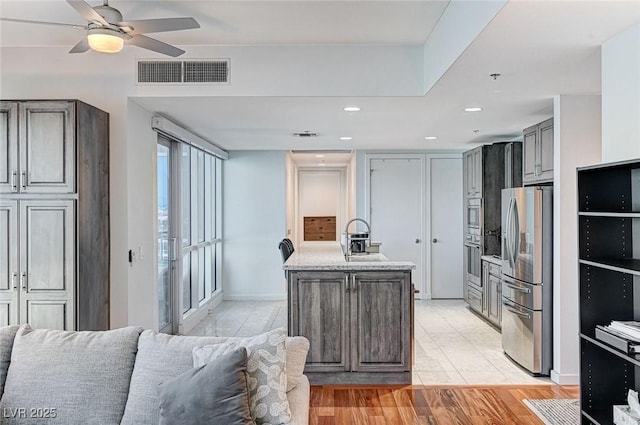 4525 Dean Martin Dr Unit 1208, Las Vegas, NV 89103 - kitchen with stainless steel fridge, ceiling fan, open floor plan, recessed lighting, and a kitchen island with sink