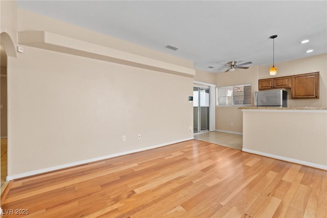 8409 Running Deer Ave Unit 203, Las Vegas, NV 89145 - unfurnished living room featuring a ceiling fan, light wood-style flooring, recessed lighting, and arched walkways