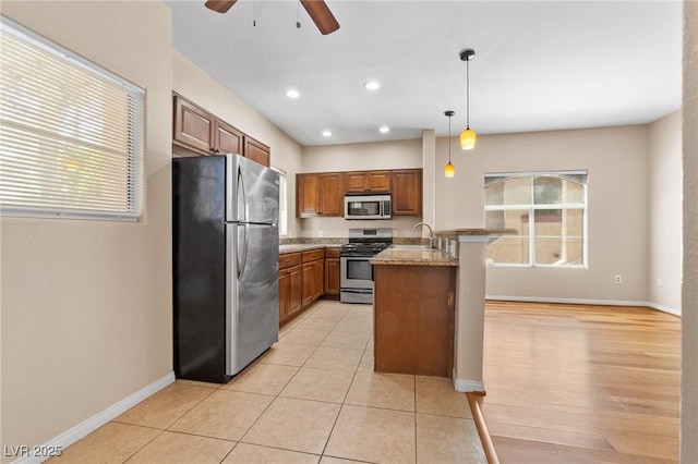 8409 Running Deer Ave Unit 203, Las Vegas, NV 89145 - kitchen with stainless steel appliances, a ceiling fan, brown cabinetry, healthy amount of natural light, and recessed lighting