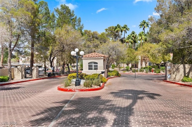 8409 Running Deer Ave Unit 203, Las Vegas, NV 89145 - view of decorative street with a gate, curbs, a gated entry, and street lights