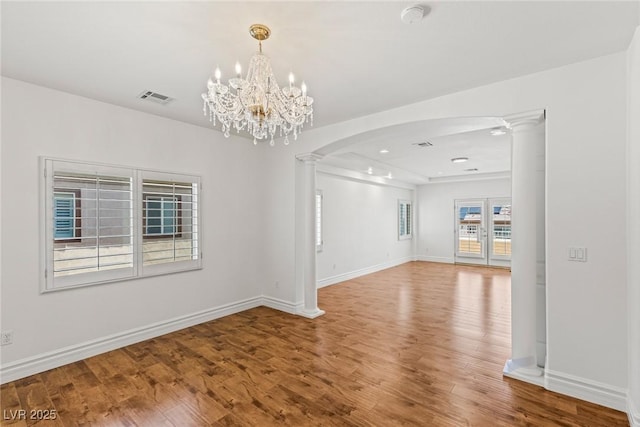 2846 Barrow Downs St, Las Vegas, NV 89135 - spare room featuring arched walkways, decorative columns, wood finished floors, and baseboards