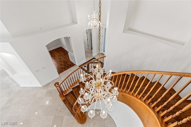 2846 Barrow Downs St, Las Vegas, NV 89135 - staircase with a chandelier, arched walkways, tile patterned floors, and baseboards