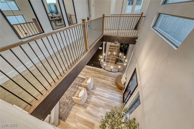 365 Crown Mesa Ave, Las Vegas, NV 89138 - living room featuring a chandelier, wood finished floors, a towering ceiling, and stairs