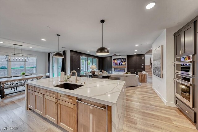 365 Crown Mesa Ave, Las Vegas, NV 89138 - kitchen featuring a sink, open floor plan, light stone counters, recessed lighting, and light wood-style flooring
