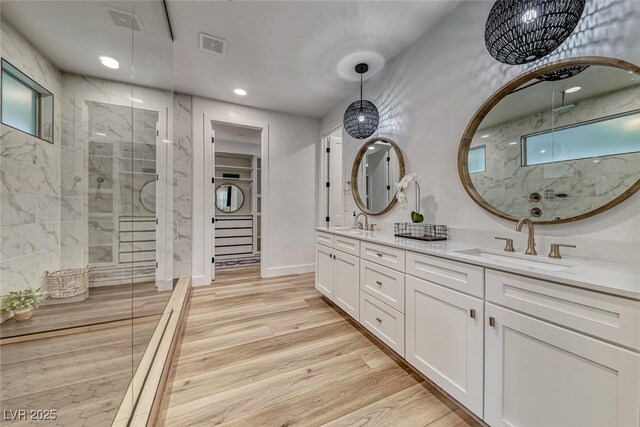 365 Crown Mesa Ave, Las Vegas, NV 89138 - bathroom with double vanity, a marble finish shower, recessed lighting, wood finished floors, and baseboards