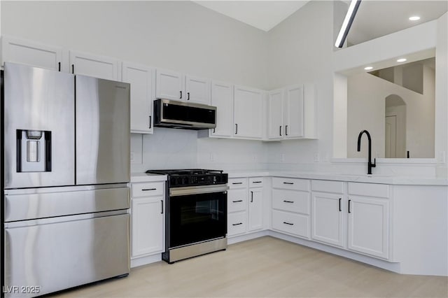 7865 March Brown Ave, Las Vegas, NV 89149 - kitchen featuring stainless steel appliances, light countertops, a sink, white cabinets, and a towering ceiling