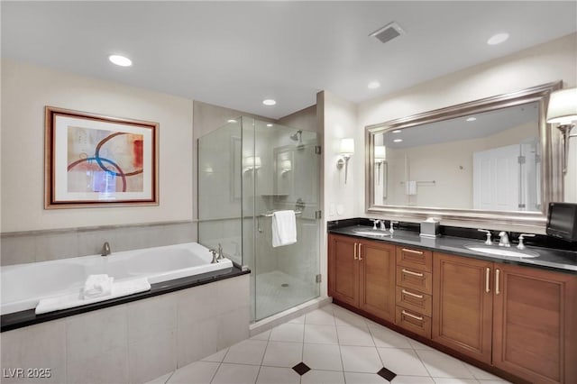 135 E Harmon Ave Unit 315, Las Vegas, NV 89109 - bathroom with double vanity, a garden tub, a stall shower, tile patterned flooring, and recessed lighting