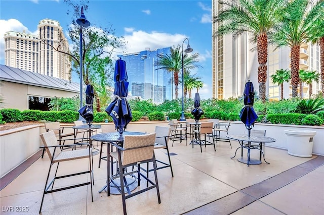 135 E Harmon Ave Unit 315, Las Vegas, NV 89109 - view of patio / terrace featuring outdoor dining area and a city view