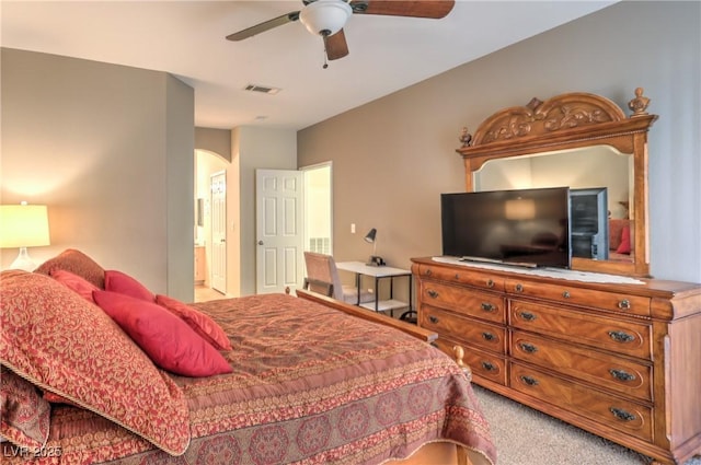 6480 Annie Oakley Dr Unit 624, Las Vegas, NV 89120 - bedroom with arched walkways, light colored carpet, ensuite bathroom, and ceiling fan
