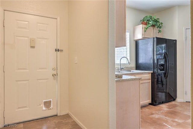 6480 Annie Oakley Dr Unit 624, Las Vegas, NV 89120 - kitchen with black refrigerator with ice dispenser, a sink, baseboards, and light countertops