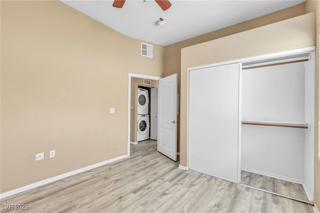 3544 Desert Cliff St Unit 102, Las Vegas, NV 89129 - unfurnished bedroom with stacked washer / dryer, wood finished floors, baseboards, a closet, and a ceiling fan
