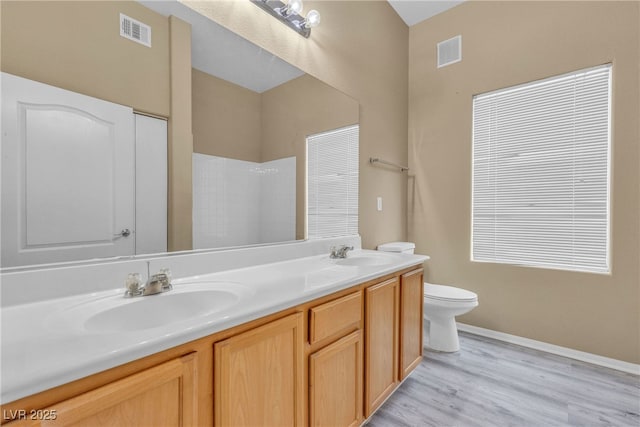 3544 Desert Cliff St Unit 102, Las Vegas, NV 89129 - bathroom featuring toilet, double vanity, a shower, wood finished floors, and baseboards