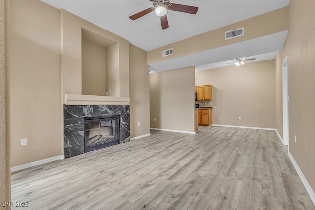 3544 Desert Cliff St Unit 102, Las Vegas, NV 89129 - unfurnished living room with a ceiling fan, light wood-style flooring, a fireplace, and baseboards