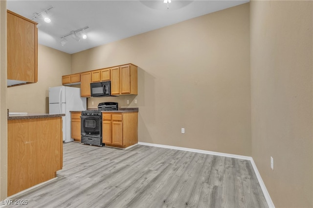 3544 Desert Cliff St Unit 102, Las Vegas, NV 89129 - kitchen featuring black appliances, light wood finished floors, baseboards, and rail lighting