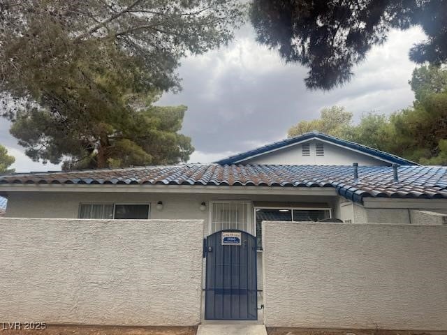 2108 Willowbury Dr Unit B, Las Vegas, NV 89108 - view of front of house featuring stucco siding, a tiled roof, and a gate