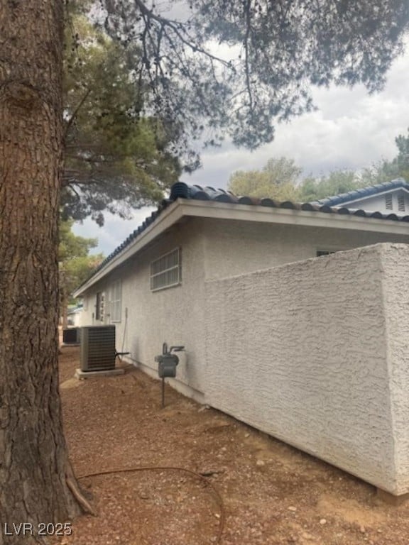 2108 Willowbury Dr Unit B, Las Vegas, NV 89108 - view of side of home with stucco siding, a tiled roof, and central air condition unit