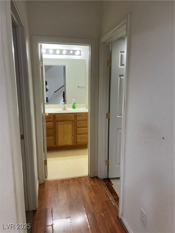 5334 Floating Flower Ave, Las Vegas, NV 89139 - hallway featuring light wood-type flooring, a sink, and baseboards
