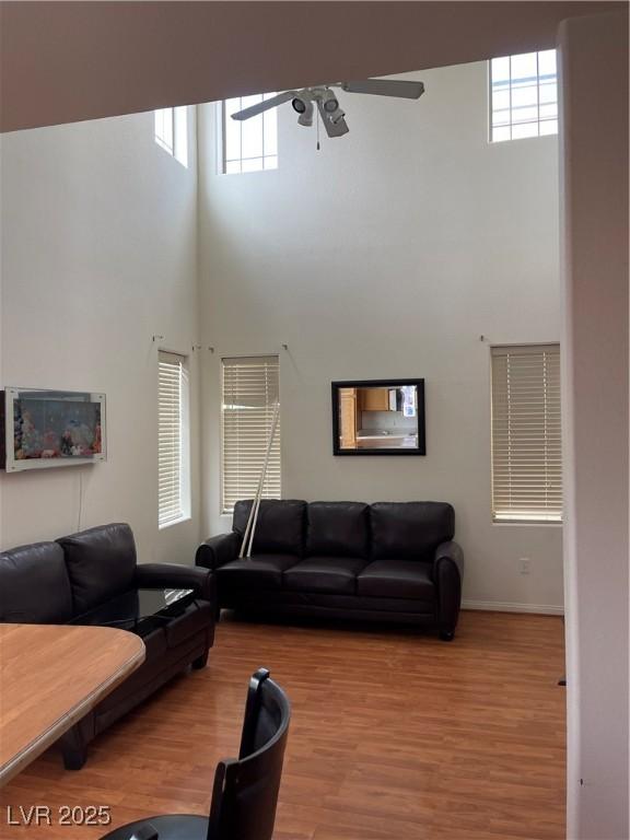 5334 Floating Flower Ave, Las Vegas, NV 89139 - living room with a high ceiling, ceiling fan, wood finished floors, and baseboards