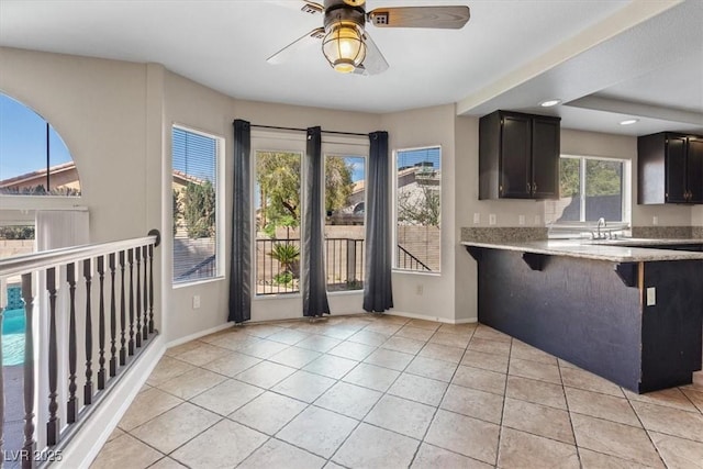 2812 Via Avanti St, Henderson, NV 89074 - kitchen with baseboards, a ceiling fan, light tile patterned flooring, a breakfast bar, and recessed lighting