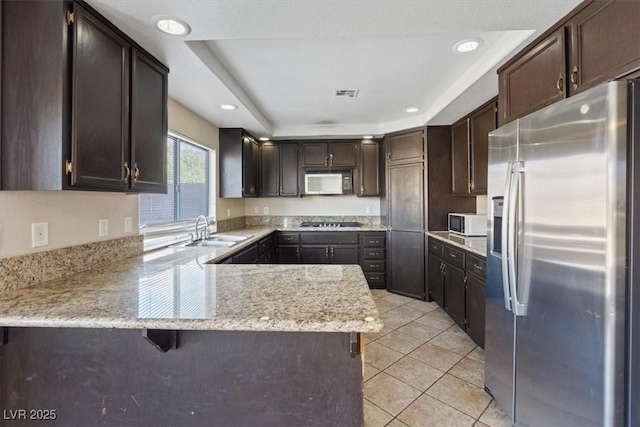 2812 Via Avanti St, Henderson, NV 89074 - kitchen featuring stainless steel refrigerator with ice dispenser, white microwave, a sink, gas cooktop, and recessed lighting
