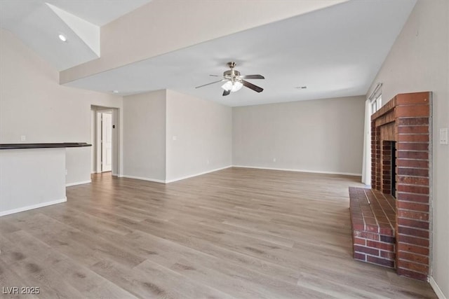 2812 Via Avanti St, Henderson, NV 89074 - unfurnished living room with a brick fireplace, a ceiling fan, light wood-style flooring, baseboards, and recessed lighting
