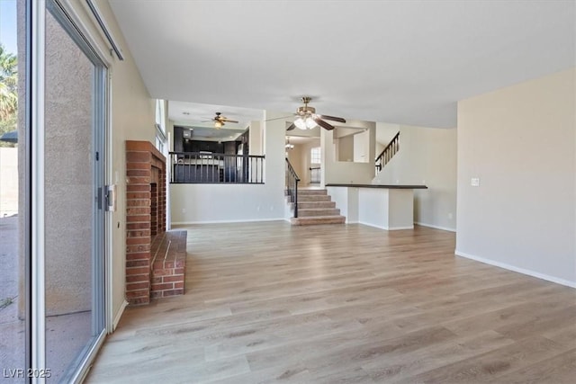 2812 Via Avanti St, Henderson, NV 89074 - unfurnished living room with stairs, wood finished floors, a brick fireplace, and a ceiling fan