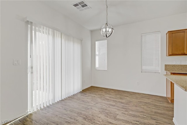 9535 Stills Way, Las Vegas, NV 89148 - unfurnished dining area featuring light wood finished floors, a chandelier, and baseboards