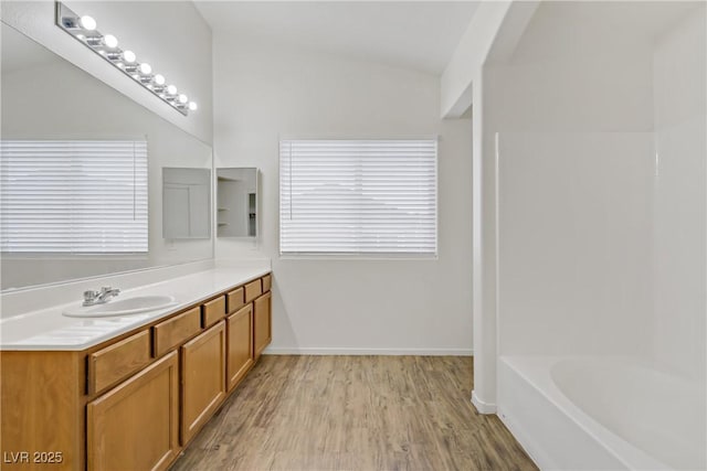 9535 Stills Way, Las Vegas, NV 89148 - full bathroom with vanity, wood finished floors, vaulted ceiling, baseboards, and bathtub / shower combination